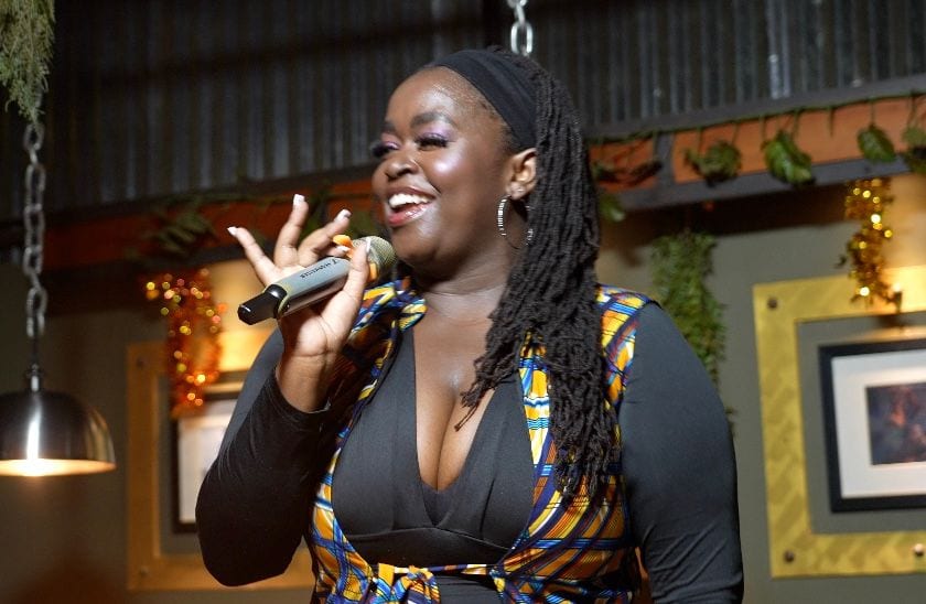 Anyumel Rose, comedian and performer, singing live in an African print top